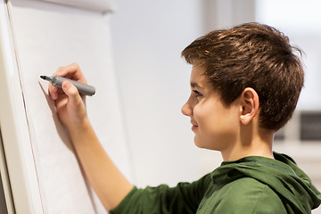 Image showing student boy with marker writing on flip board