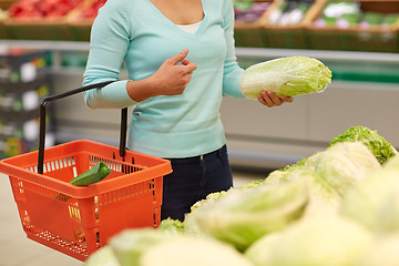 Image showing woman with basket and chinese cabbage at grocery