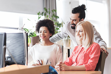 Image showing happy creative team with computer in office