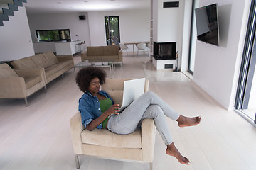 Image showing African American women at home in the chair using a laptop