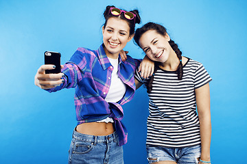 Image showing best friends teenage girls together having fun, posing emotional on blue background, besties happy smiling, lifestyle people concept 