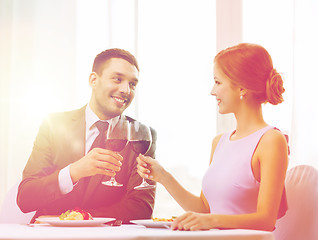 Image showing couple with main course and red wine at restaurant