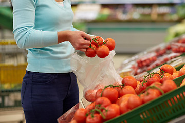 Image showing woman with bag buying tomatoes at grocery store