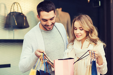 Image showing happy couple with shopping bags at shop window