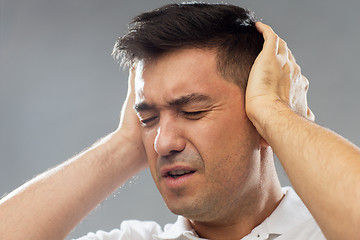 Image showing close up of man suffering from noise closing ears