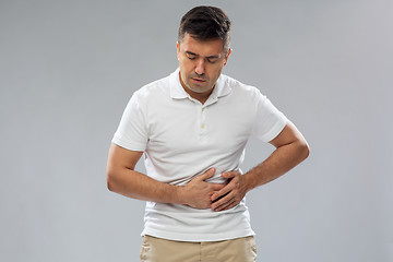 Image showing unhappy man suffering from stomach ache