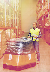 Image showing man carrying loader with goods at warehouse