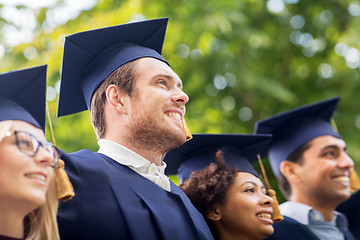 Image showing happy students or bachelors in mortar boards