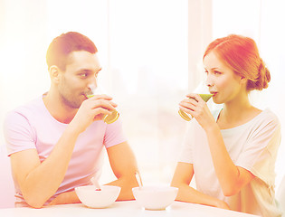 Image showing smiling couple having breakfast at home