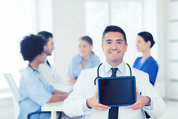 Image showing happy doctor with tablet pc over team at clinic