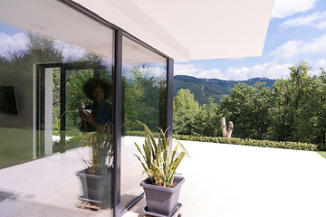 Image showing African American woman drinking coffee looking out the window