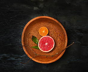 Image showing Grapefruit citrus fruit halves on wooden plate