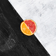 Image showing Grapefruit and orange citrus fruit halves on wooden