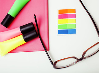 Image showing business, education and technology concept - close up of notebook, paper stickers, glasses, pencil different stuff on white background