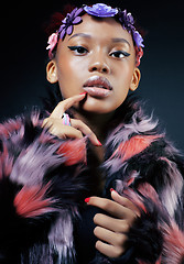 Image showing young pretty african american woman in spotted fur coat and flowers jewelry on head smiling sweet etnic make up bright