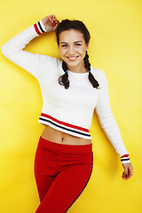 Image showing young pretty teenage girl emotional posing on yellow background, fashion lifestyle people concept 