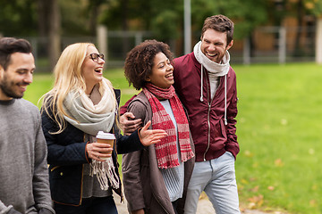 Image showing happy friends walking along autumn park