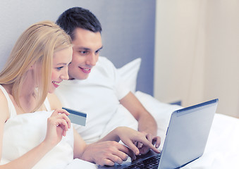 Image showing couple in bed with laptop computer and credit card