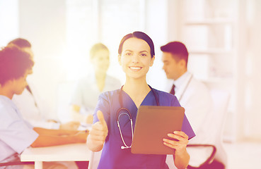 Image showing happy doctor with tablet pc over team at clinic