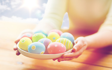 Image showing close up of woman hands with colored easter eggs