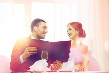 Image showing smiling couple with menu at restaurant