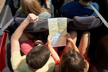 Image showing happy friends with map driving in convertible car