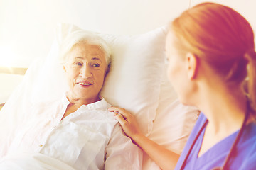 Image showing doctor or nurse visiting senior woman at hospital