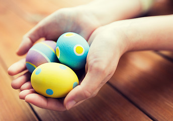 Image showing close up of woman hands with colored easter eggs