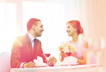 Image showing smiling man giving flower bouquet at restaurant