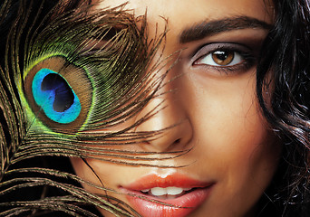 Image showing young sensitive brunette woman with peacock feather eyes close up on green smiling, lifestyle people concept