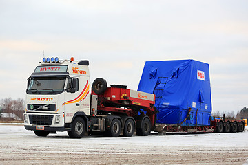 Image showing White Volvo FH16 Semi Trailer Hauls Wide Load in Winter