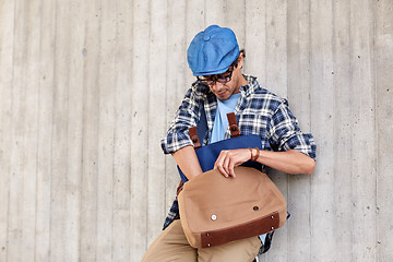 Image showing hipster man looking for something in his bag