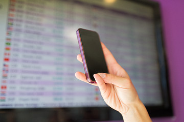 Image showing hand with smartphone over exchange rates on screen