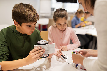 Image showing happy children building robots at robotics school