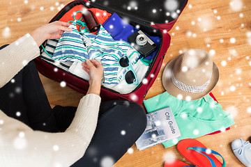 Image showing close up of woman packing travel bag for vacation