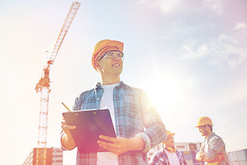 Image showing builder in hardhat with clipboard at construction