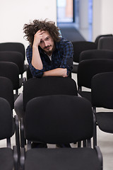 Image showing A student sits alone  in a classroom