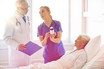 Image showing doctor giving medicine to senior woman at hospital