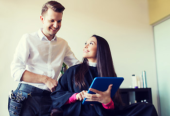 Image showing happy woman and stylist with tablet pc at salon