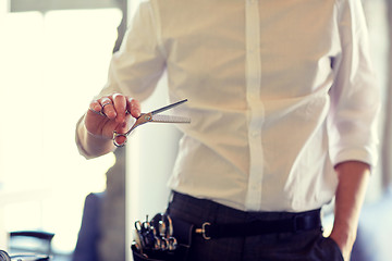 Image showing close up of male stylist with scissors at salon