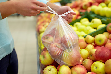 Image showing woman with bag buying apples at grocery store