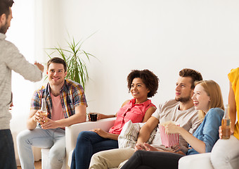 Image showing friends with popcorn and drinks talking at home