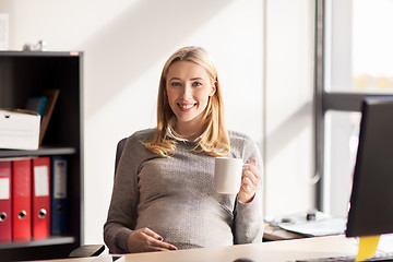 Image showing pregnant businesswoman with cup of tea at office