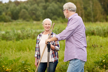 Image showing senior couple with garden tools working at farm