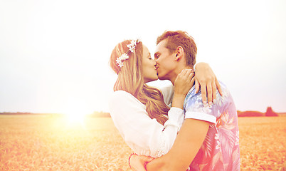 Image showing happy young hippie couple kissing in field