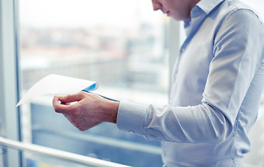 Image showing businessman with clipboard and papers in office