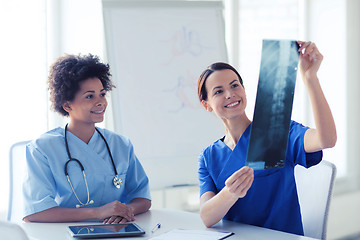 Image showing happy female doctors with x-ray image at hospital