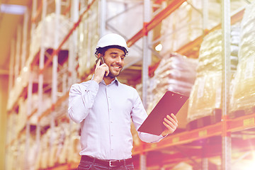 Image showing man with clipboard and smartphone at warehouse