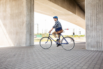 Image showing young hipster man with bag riding fixed gear bike