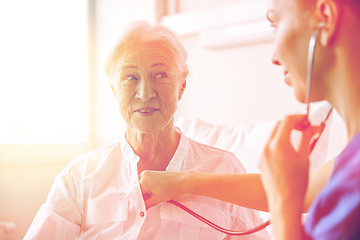 Image showing nurse with stethoscope and senior woman at clinic